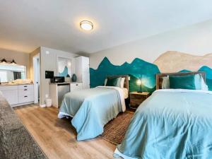 two beds in a bedroom with a blue wall at Mountain Room At The Trailblazer Unit 16 in Townsend