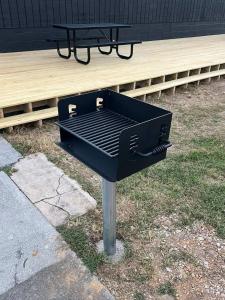 a black barbecue grill with a picnic table in the grass at Mountain Room At The Trailblazer Unit 16 in Townsend