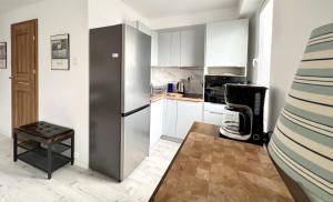a small kitchen with a stainless steel refrigerator at Apartamenty Marea Rentals Grunwaldzka Ustka in Ustka