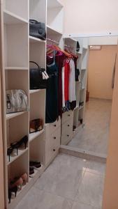 a walk in closet with white shelves and shoes at Seyramz Palace in Tamale