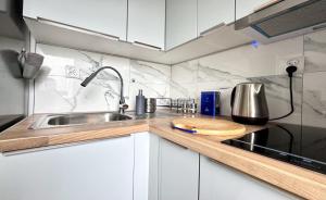 a kitchen with a sink and a counter top at Apartamenty Marea Rentals Grunwaldzka Ustka in Ustka
