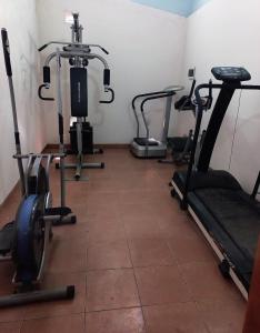 a gym with several tread machines in a room at Colorina Complejo Residencial in San Rafael