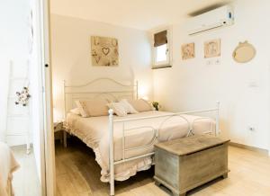 a bedroom with a white bed with a wooden floor at Casa vacanze La Scala d'Oro in Orvieto