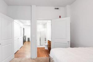 ein weißes Schlafzimmer mit einem Bett und einem Badezimmer in der Unterkunft 2Bdrm Apartment 2 Blocks Away from UNC with Gym in Greeley