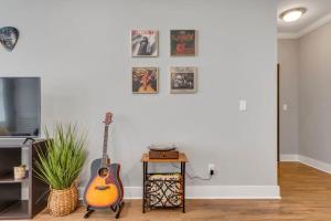 a living room with a guitar and a table at Modern Nations Condo - Walkable - 5 Mi Downtown in Nashville +21 photos
