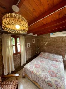 1 dormitorio con cama y lámpara de araña en Cabaña Balcón Serrano en Cortaderas