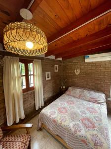 a bedroom with a bed and a chandelier at Cabaña Balcón Serrano in Cortaderas +46 photos