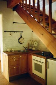 a kitchen with a sink and a stove and a staircase at Poganty - Mały Domek in Giżycko