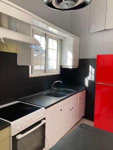 a kitchen with a sink and a red refrigerator at JIM in Andravída