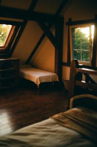 a attic room with a bed and a window at Poganty - Mały Domek in Giżycko