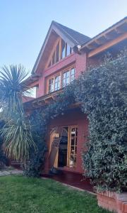 a red brick house with a tree in front of it at Colorina Complejo Residencial in San Rafael