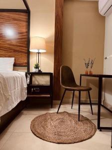 een slaapkamer met een stoel, een bed en een bureau bij Casa Victoria Malecon in Puerto Vallarta