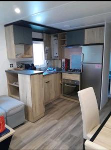 une cuisine avec des placards en bois et des appareils en acier inoxydable dans l'établissement Mobil home, à Piriac-sur-Mer