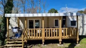 a tiny house with a porch and a deck at Mobil home in Piriac-sur-Mer