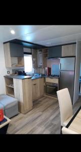 a large kitchen with wooden cabinets and a white couch at Mobil home in Piriac-sur-Mer