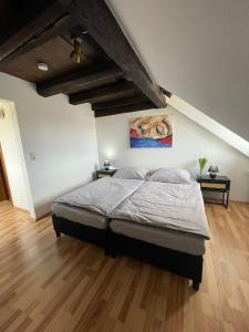 a bedroom with a bed and a wooden floor at CASA RUSTICA Bodensee Ferienwohnungen in Stetten