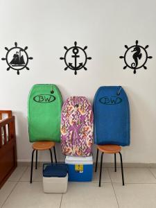 two chairs sitting next to a wall with anchors at Apartamento Pé na Areia - Praia Grande in Praia Grande