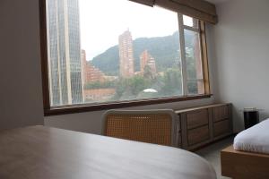 a room with a bed and a large window at Amazing Vintage Apartment in Centro Internacional RColon 601 in Bogotá