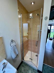 a bathroom with a shower and a sink at Kilcoy Chalets in Muir of Ord