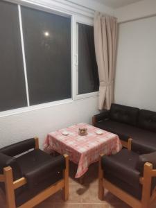 ein Wohnzimmer mit einem Tisch und einem Sofa in der Unterkunft VILI APARTMENTS STAR DOJRAN in Star Dojran