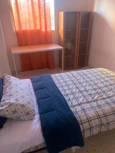 Un dormitorio con una cama con una manta azul. en Habitacion en Piso Cerca Playa, en Alicante