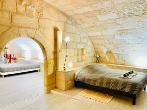 una camera con due letti in una parete in pietra di Loft Bordelais a Bordeaux