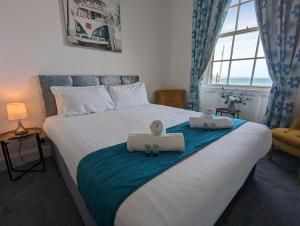 a bedroom with a bed with two towels on it at Acqua Beach Weymouth in Weymouth