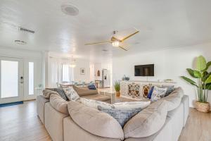 a living room with a large couch and a ceiling fan at Charming Riverfront Home with Kayaks! in Crystal River
