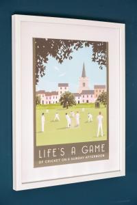 a framed picture of a game of cricket on a sunny afternoon at Royal Ashton Townhouse - Taunton in Taunton
