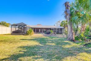 a house with a palm tree in front of it at Charming Riverfront Home with Kayaks! in Crystal River