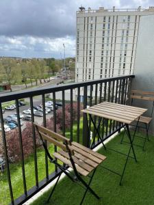 ławka i stół na balkonie z budynkiem w obiekcie Apartment in Calm Neighborhood w mieście Eaubonne