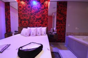 Un dormitorio con una cama con una bolsa negra. en Karinho Hotel 4 en Santo André