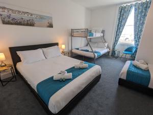 ウェイマスにあるAcqua Beach Weymouthのベッドルーム1室(ベッド2台、二段ベッド1組付)