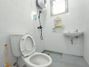 villa puncak bogor by GO puncak في Cikundul: حمام به مرحاض أبيض ومغسلة