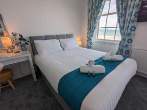 a bedroom with a bed with towels on it at Acqua Beach Weymouth in Weymouth