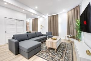 uma sala de estar com um sofá e uma televisão em Modern & Bright 3BR with Sofabed in Mile-End em Montreal