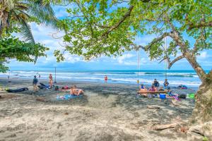 a group of people sitting on a beach at Atlantida Lodge Cahuita in Cahuita