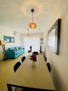 salon ze stołem i niebieską kanapą w obiekcie Beach/ Pool Apartment Cadaques Bayahibe w mieście La Romana