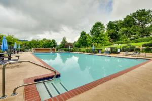 una gran piscina azul con sillas y sombrillas en Sky Valley Retreat with Fire Pit and Mountain Views! en Dillard