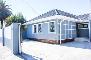 a small house with a gate in front of it at Botha Villa Lodge Goodwood in Cape Town
