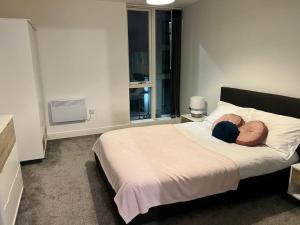 a person laying on a bed in a bedroom at Lovely 2 bedroom Apartment in Central Manchester in Manchester