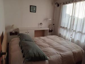 um quarto com uma cama com almofadas verdes em Para Toda la Familia em Puerto Madryn