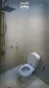 a bathroom with a white toilet in a stall at شاليه النجمه الذهبيه in Al Harazat