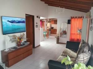un soggiorno con divano e TV a schermo piatto di Para Toda la Familia a Puerto Madryn