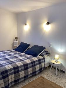 una camera con un letto blu e bianco e un tavolo di La Casa d'Isabelle, Charme Corse à Patrimonio a Patrimonio