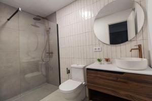 y baño con aseo, lavabo y espejo. en Tartessos Apartamentos 1 en Sevilla