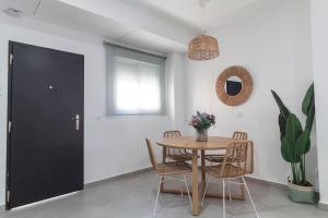 comedor con mesa, sillas y ventana en Tartessos Apartamentos 1 en Sevilla