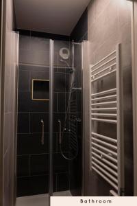 a bathroom with a shower with black tiles at Chambres cosy près de Paris in Asnières-sur-Seine
