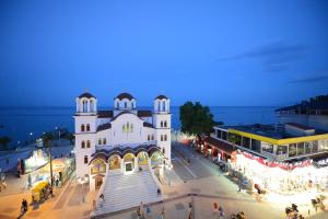 um grande edifício branco com pessoas de pé na frente dele em Central Hotel em Paralia Katerinis