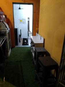 una stanza con tavolo, due panche e una porta di Bapuji Paying Guest Santacruz West a Mumbai